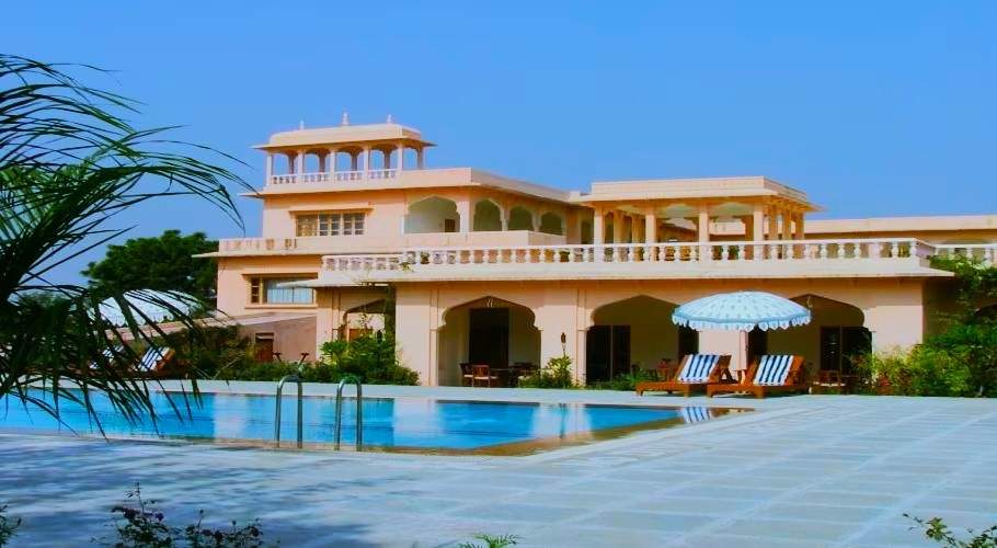 A beautiful view of Dev Vilas Hotel nestled in the Aravalli Hills, offering a luxurious and traditional Rajasthani experience amidst nature.