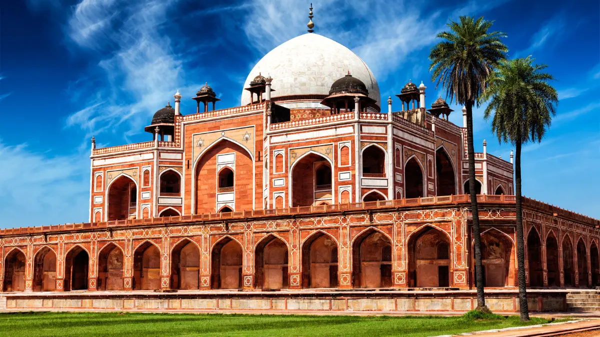A photo of Humayun's Tomb, a white marble tomb in a lush garden in Delhi, India.